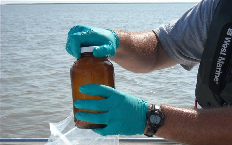 Collecting a water sample in a sterile bottle for laboratory testing